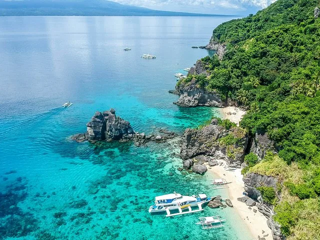 Luchtfoto van de kust van Apo Island met boten in helderblauw water